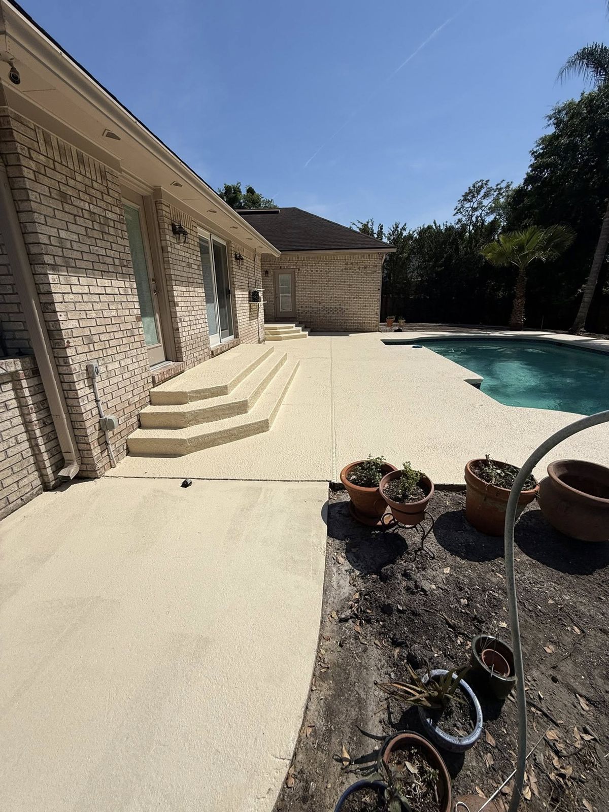 Pool deck and patio with a neutral decorative concrete coating at a Jacksonville home